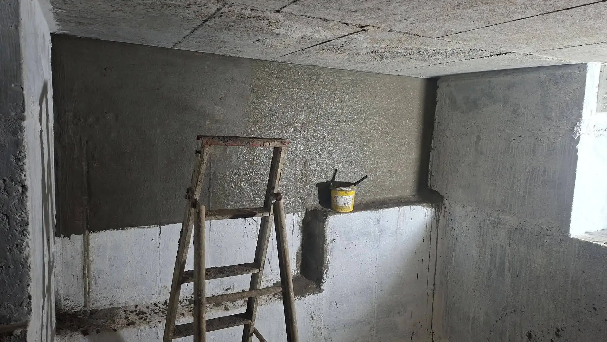 Waterproof coating being applied to concrete basement walls